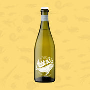 A bottle of The Hidden Sea Prosecco standing upright against a pale yellow background patterned with faint ocean-inspired illustrations. The bottle is olive-green with white screen-printed branding featuring the Hidden Sea whale logo and the text “The Wine That Saves The Sea – Limestone Coast Prosecco.” A matte grey neck label wraps the top, and the bottle has a white closure.